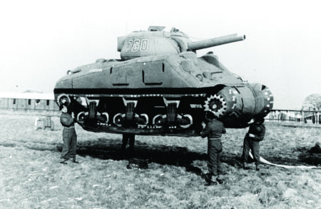 A photograph of four soldiers carrying an inflatable M4 tank into position.